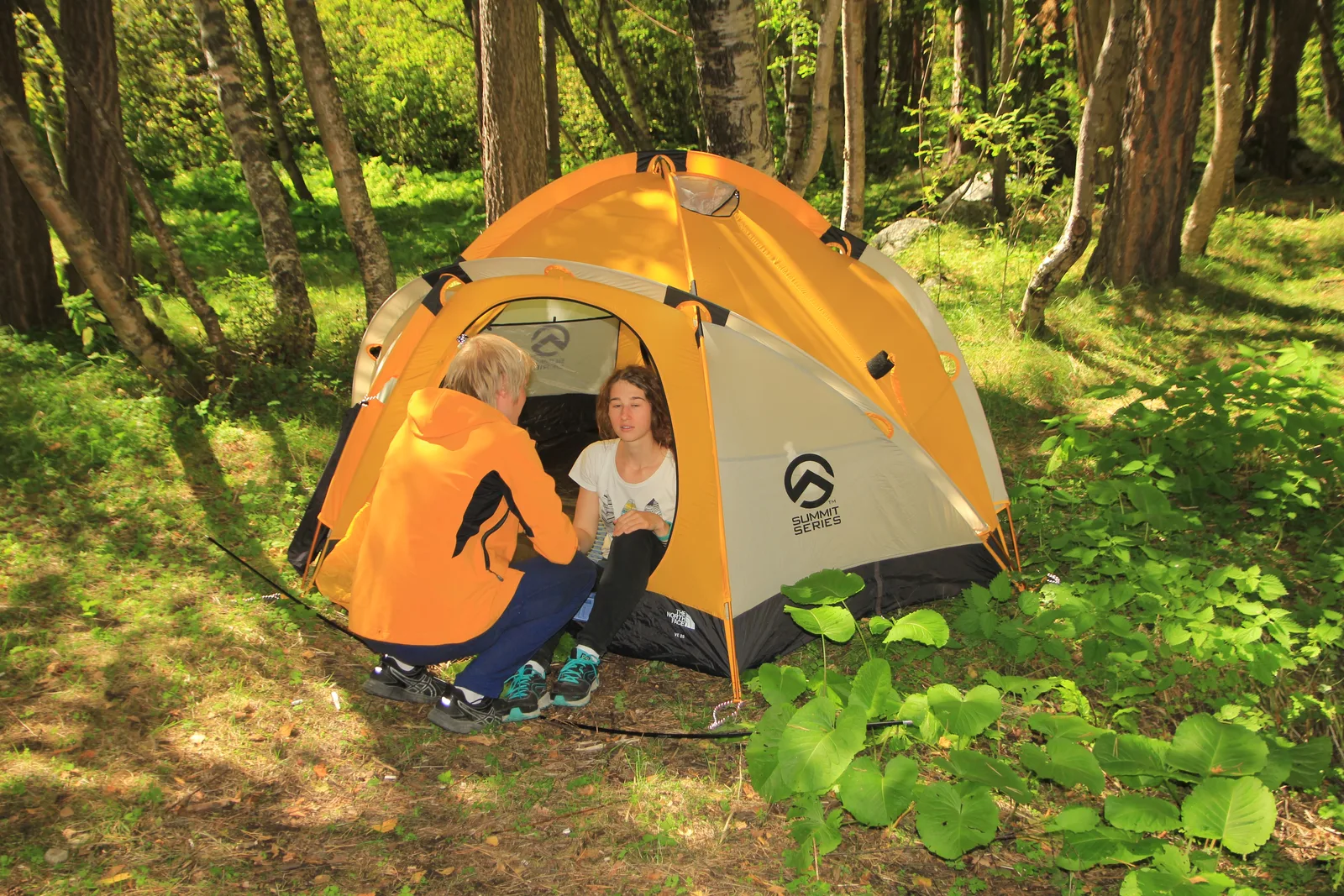 Guests beside a tent at the campsite